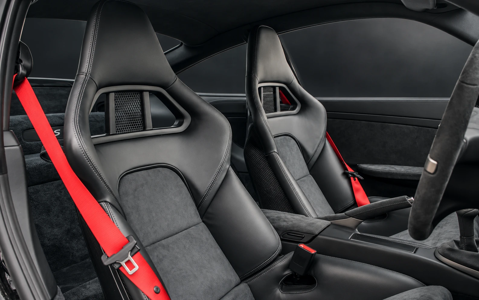 Bucket seats with carbon-fibre shells, trimmed in black leather and Alcantara, with red seat belts